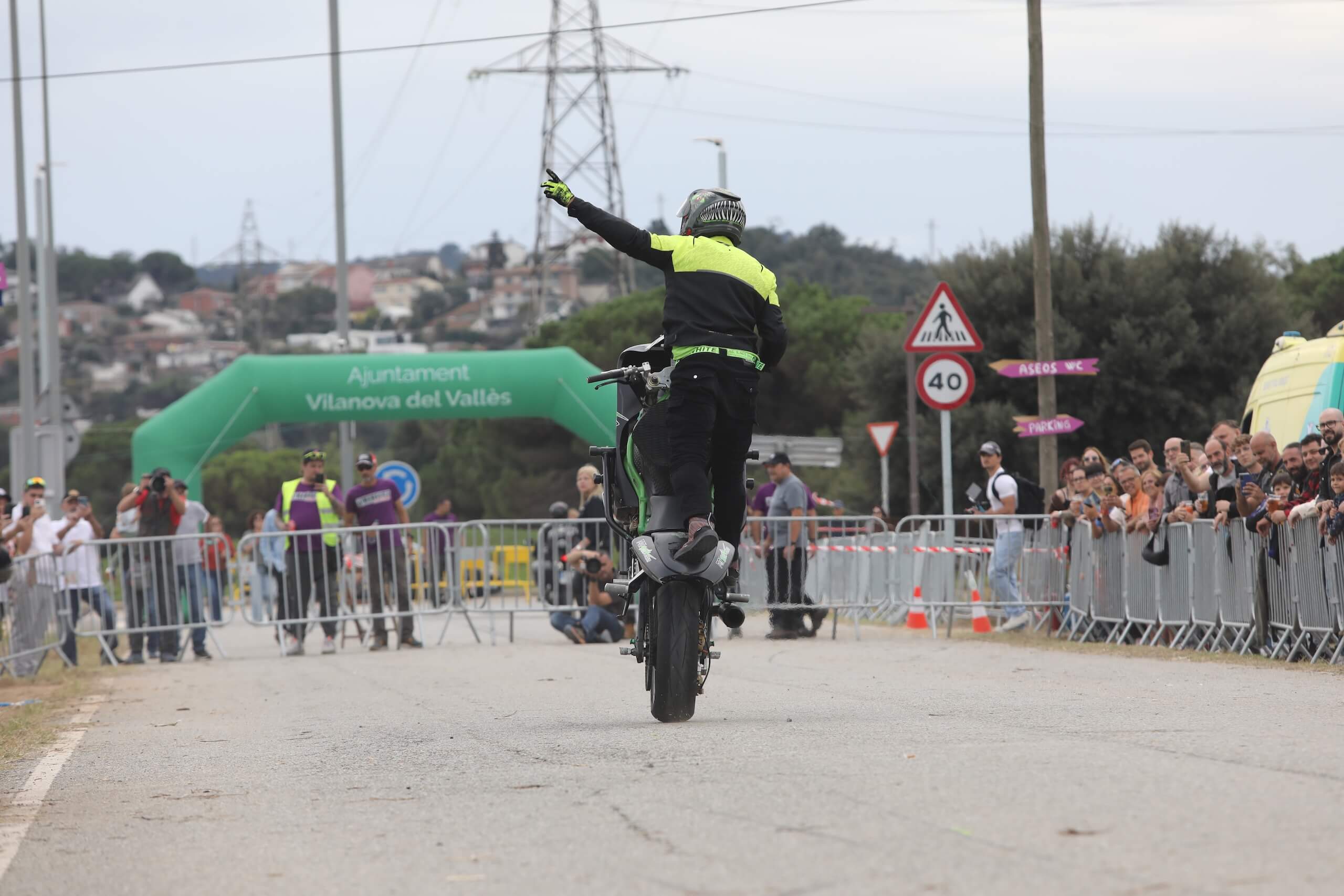 Wheelie controlado con vallas y arco del Ajuntament de Vilanova del Vallès de fondo